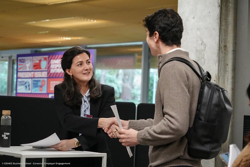 recruteuse serrant la main à un étudiant