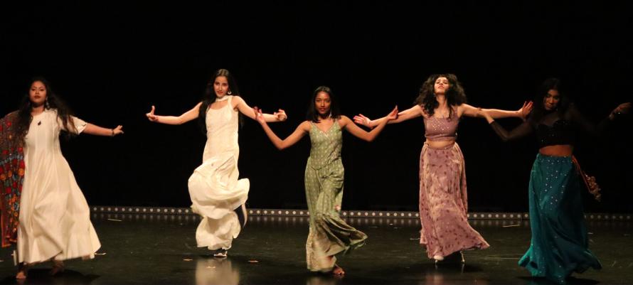 Students dance on stage to celebrate Diwali